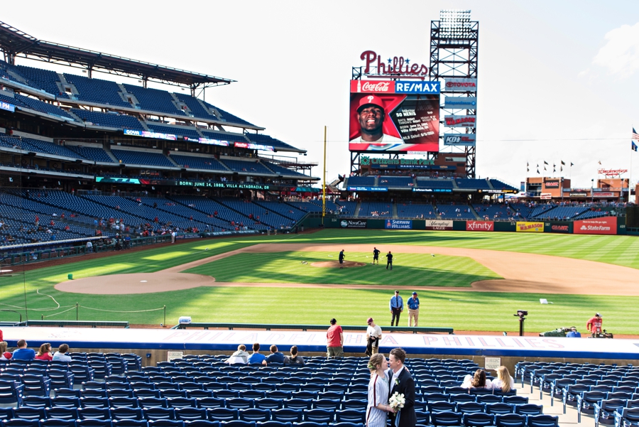 A newly married couple kiss in the seats at Citizens Bank Park.